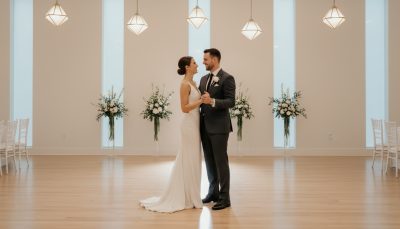 Bride and groom posing on a wedding dance floor with a minimalist backdrop.