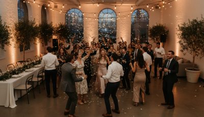 Wedding guests dancing and enjoying the reception with a minimalist background.